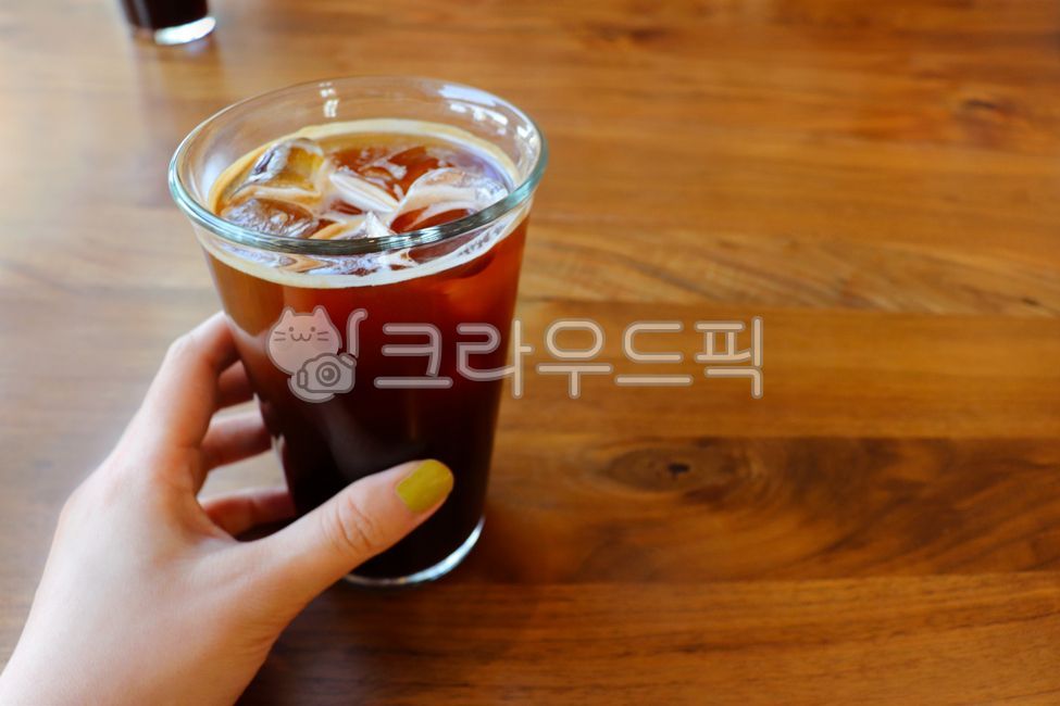 wooden table,friendly,iced,ice,awake,hold,tea,wood grain,wood,cube,woodentable,glass,reflection,nail,old,brew,brown,delicious,water,drink,morning,cafe,person,background,vintage,served,calorie,Americano,tasty,breakfast,mug,cup,Ice americano,woman,cappuccin