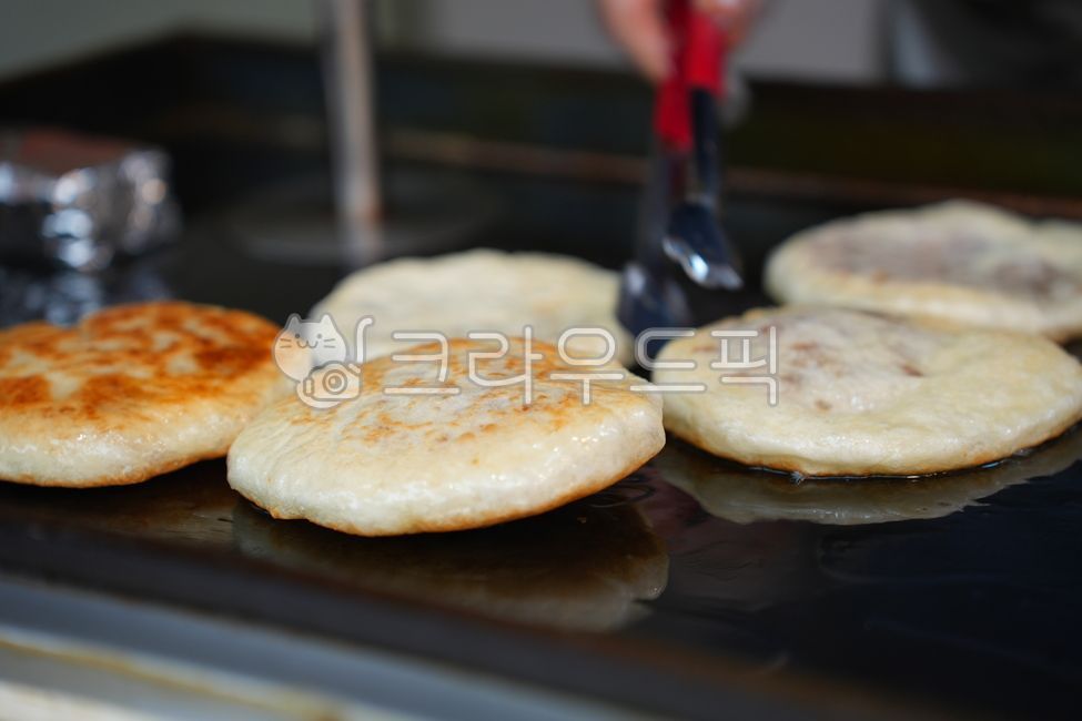 Hotteok,Korean food,street food,pancake,snack,winter,dessert,cooking,preparation,making process,griddle,oil,frying,dough,hand,press,close-up,tradition,traditional food,culture,Asia,Korea,Seoul,market,street stall,delicious,warm,