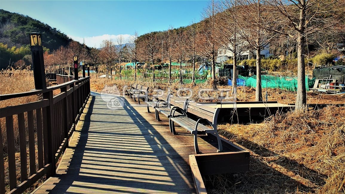 sidewalk,shelter,shadow,nature,street lights,benches,trail,walking trail,mountain,deck path,outdoors,mountain village,background,buildings,houses,chairs,bridge,village,boardwalk