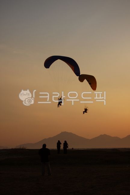 sky,gliding,parachute,paragliding,ocean,person,sunset,leisure activities,leisureactivities