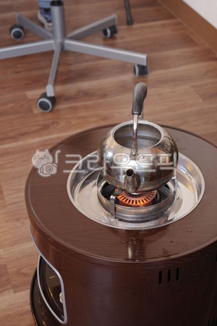kettle,stove,fire,flame,handle,burner,metal,floor,wheel,heat,structure,plate,round,light,indoor,machine,grip,heater,loop,warmth