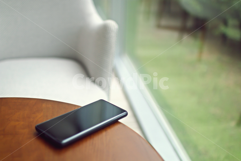 rest,wait,smartphone,lounge,chair,cell phone,brown,comfort,afternoon,call,emotion,lobby,mobilephone,cellphone,time,window,table,lawn,solitude