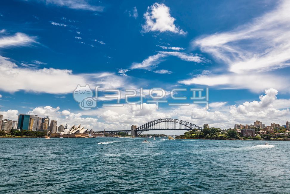 ship,passenger ship,famous place,trees,building,weather,cityscape,bay,skyscrapers,landmark,sunny,sky,development,metropolis,tourist destination,skyscraper,economy,water,operahouse,port,transit,cruise,waterfront,bridge,Sydney,archbridge,opera house,city,cl