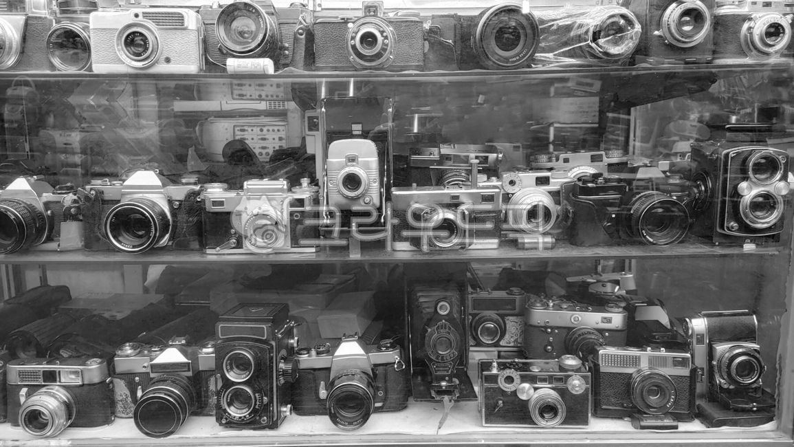 old,mechanical camera,display,black and white photography,collectibles,decorations,collection,electromechanical,bw,vintage,machine,background,curios,showcase,camera,filmcamera,film camera