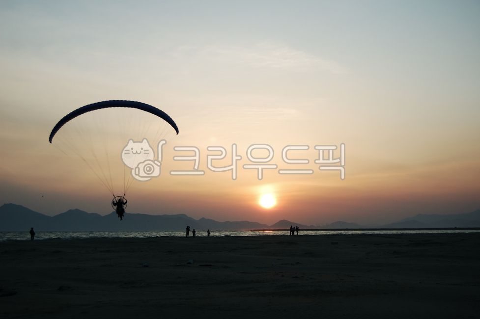 sky,gliding,parachute,paragliding,ocean,sunset,leisure activities,leisureactivities