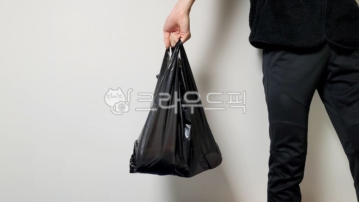 black envelope,envelope,black plastic bag,person,bag,plastic bag,vinyl,hand
