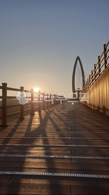 sidewalk,sky,handrail,nature,sky background,sky bridge,sunset light,sun,wooden bridge,sunlight,outdoors,road,light,railing,sunset,bridge,boardwalk