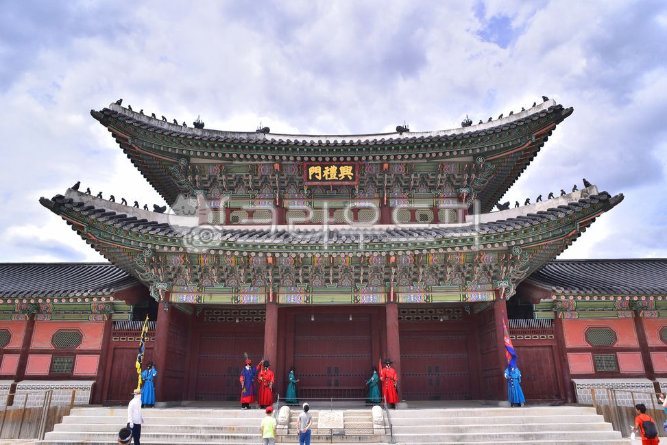 blue sky,cultural relics,Korean traditional style,building,gatekeeper,architectural style,Gyeongbokgung,Cultural Heritage,tile roof,human,unique color,architecture,sentry,Palace,Keeper,Joseon Dynasty,Heungyemun,eaves,person,Dancheong,old palace,Korean tra