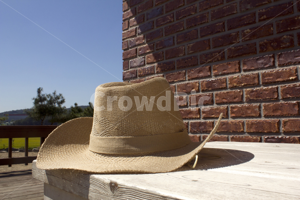모자,카우보이,남자모자,갈색,브라운,패션,산,녹색,그린,나무테이블,테이블,카우보이모자,남자패션,남성패션,악세사리,베이지,벽,벽면,블럭,벽돌,붉은벽돌,농촌,시골