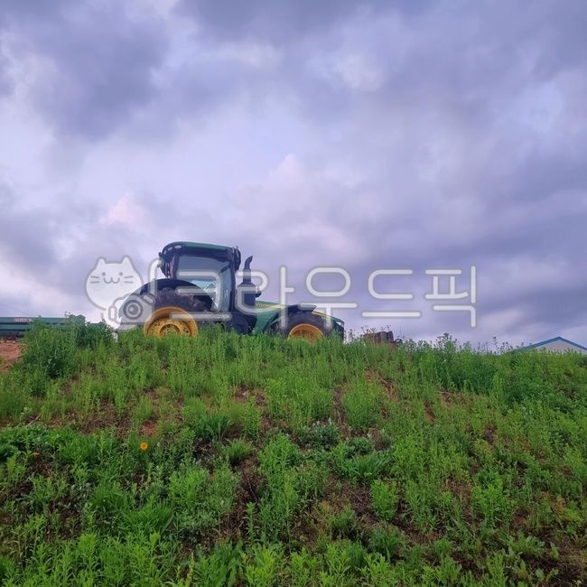 field view,parking,country tractor,Tractor parking,countryside view,cloudy weather,heavy equipment,excavator,a flaming sunset,dark clouds,tractor,sunset,telephone pole,country field,lawn