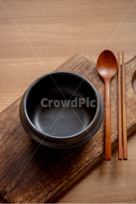 Ttukbaegi directing,wooden table,black,chopsticks,Black earthenware pot,emptyhanded,Spoon,earthen pot,cutting board,wooden cutting board,wooden spoon,cutlery set
