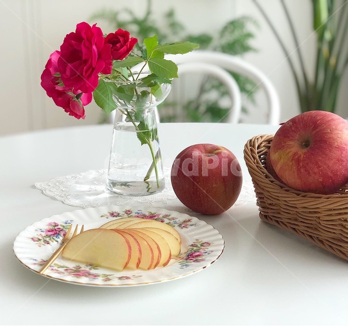 apple,basket,fork,dining table,plate,vase,table