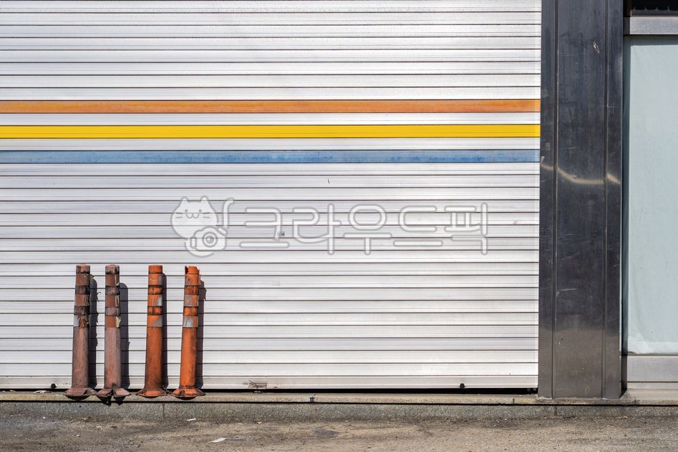 셔터,건물외벽,차고문,철제문,색줄무늬,도로시설,안전봉,플라스틱기둥,파손된시설물,거리풍경,구조물,빈공간