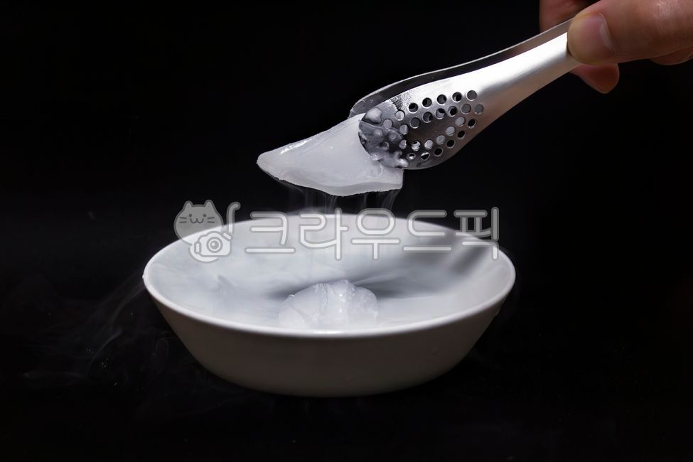 dry ice,lump,tongs,hand,plate,cold,white smoke,cooling,cooling,carbon dioxide,gas,solid,moisture,water vapor,sublimation,frozen food,moist,moisture,cloudy,dryice
