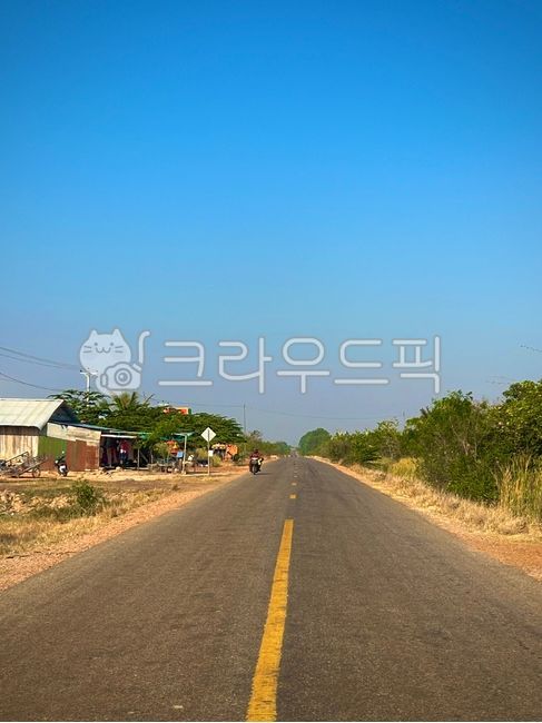 sky,freeway,roadside,nature,straight road,clear sky,trees,calm,road,grass,highway,open,languid afternoon