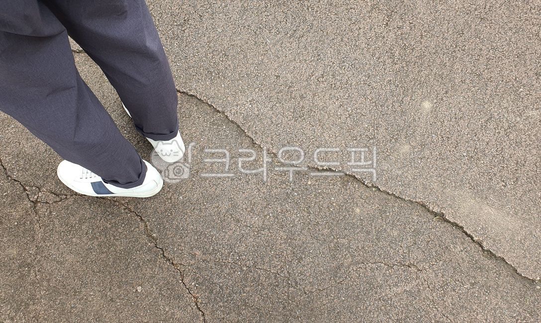 concrete,rough,pants,line,back,cracked,gold,crack,split,road,walking,bumpy,foot,group,tar,texture,length,asphalt,shoes,road surface,running shoes,person,road name