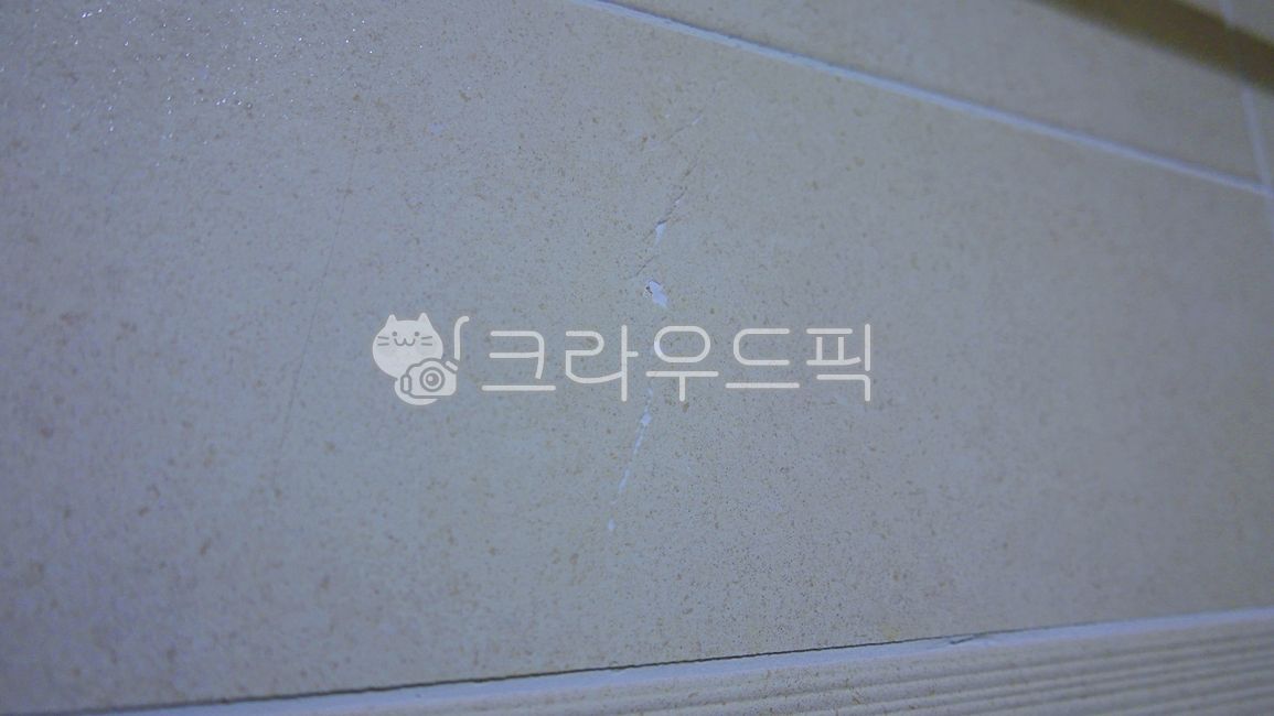 cracked tile,broken tile,tile,inside,wall,restroom