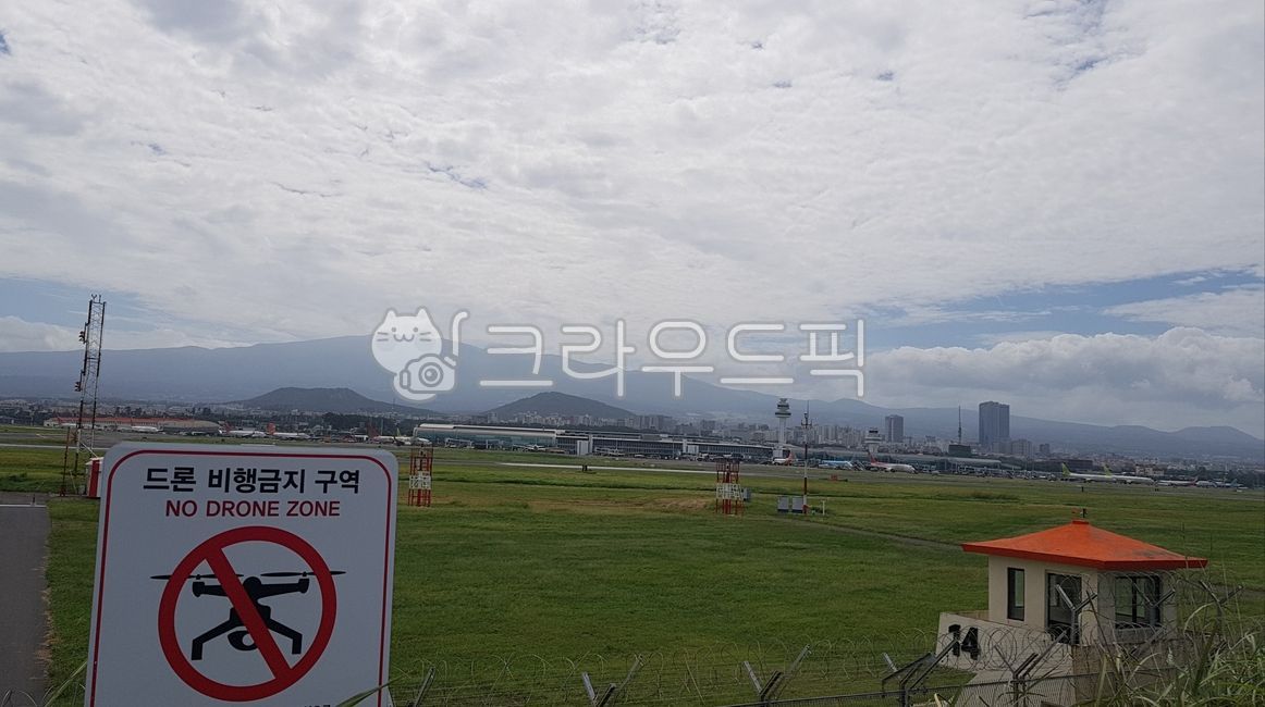 Drone nofly zone,sky,Mt Hanlla,building,cloud,outdoors,Jeju Airport Runway,background,Jeju Airport,airplane,airliner,rise