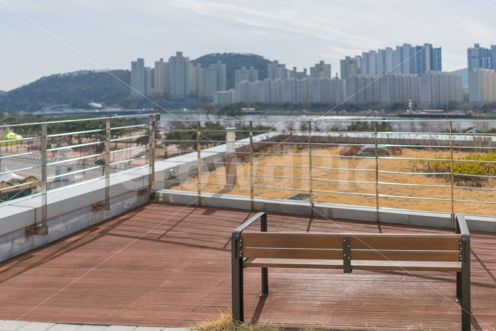 야외,테라스,벤치,의자,휴식,밝은,푸른하늘,힐링,커피타임,도시,도심,탁트인,전망,풍경,점심시간,아무도없는,쓸쓸한,외로운,빈의자,빈벤치,텅빈,조용한,고민,혼자생각하기,사색,광합성,태양,햇빛,따뜻한,봄햇살,봄기운,강이보이는,나무테라스,시원한,신선한공기,맑은공기,강,나른한,재충전,나무목조,목조바닥,아파트,도시,풍경,city,landscape,bench,furniture,가구