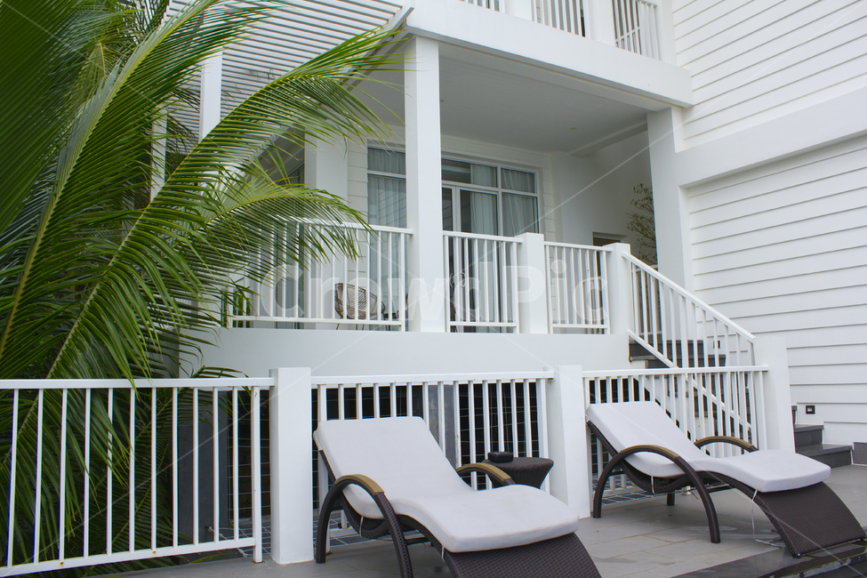 porch,현관,railing,난간,나무,식물,자연,나뭇잎,잎사귀,녹색,그린,초록색,야자수,야자나무,주택,집,하우스,팬션,리조트,베란다,의자,체어,비치의자,가구,휴식,휴양,라탄,라탄의자,벽,벽면,건축,건설,베트남,푸꾸옥,창문,썬배드,썬베드