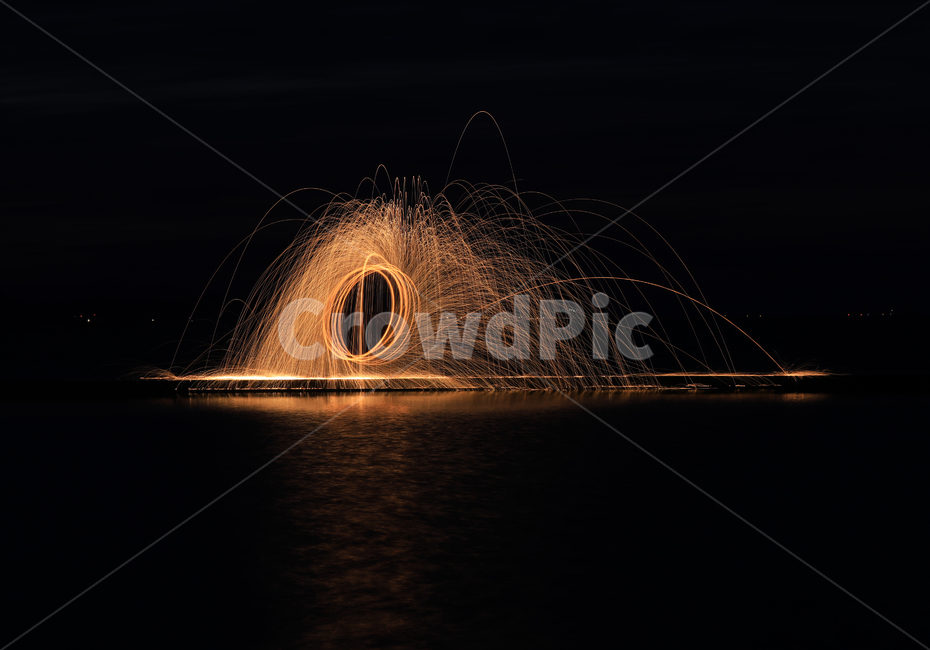 night view,reflection,line,rotation,night,light line,fireworks,water,sea,iron cotton fireworks,iron wool,beach,dark,evening,flash