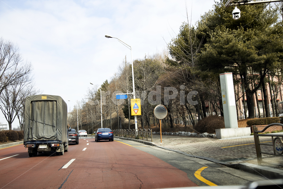 어린이보호구역,속도제한,횡단보도,학교앞,자동차,차선,아스팔트,감시카메라,나무,가로등,반사경,트럭,승용차,서행,어린이보호,속도,사고위험,경고,학교,스쿨존,노란색,교통표지,교통,transportation,차량