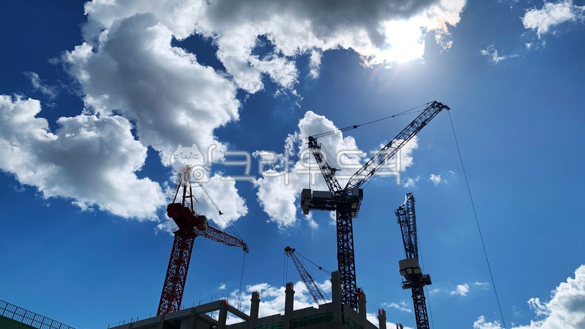 sky,cloud,building,construction,factory,plant,crane,towercrane,sun,sunshine,clear